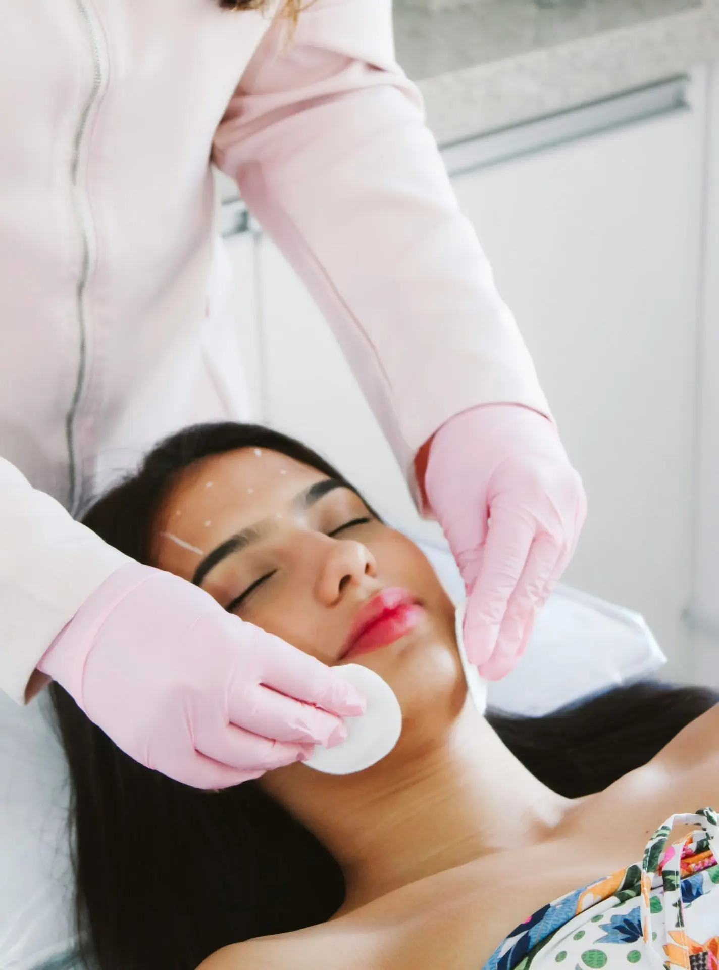 A woman getting a facial mask on her face